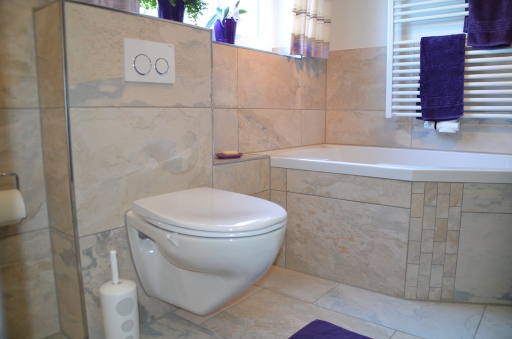 Wand-WC und geflieste Badewanne